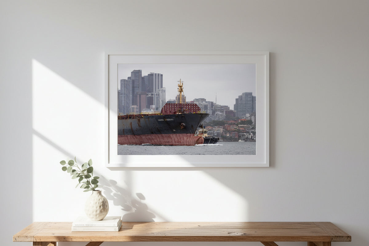 Fuel tanker and tug boat leaving Sydney Harbour with city skyline in background.
