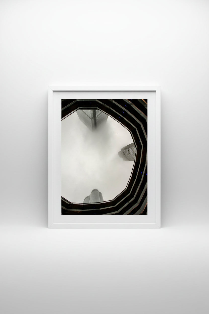 View through the Vessel in New York up to tall buildings shrouded in fog.
